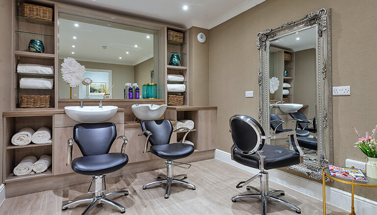 Modern, well-stocked and tidied hair salon with styling chairs and a hair washing sink